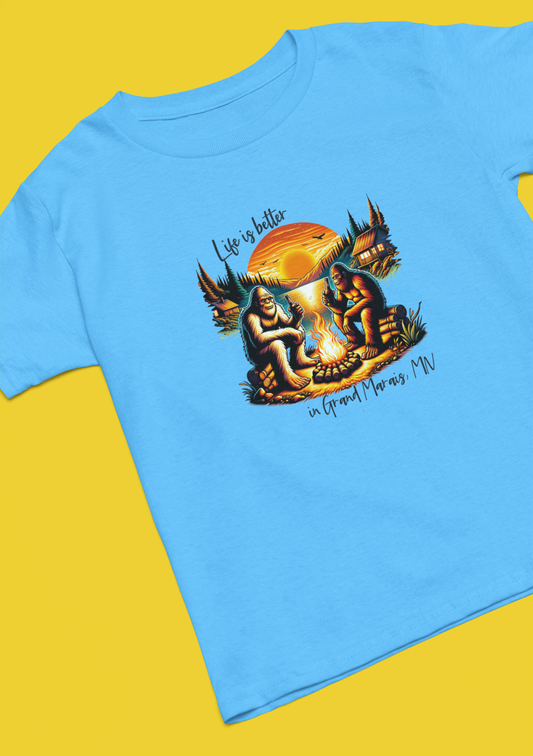 Life is better in...YOUR LOCATION - Bigfoot campfire shirt: Carolina blue / Sm